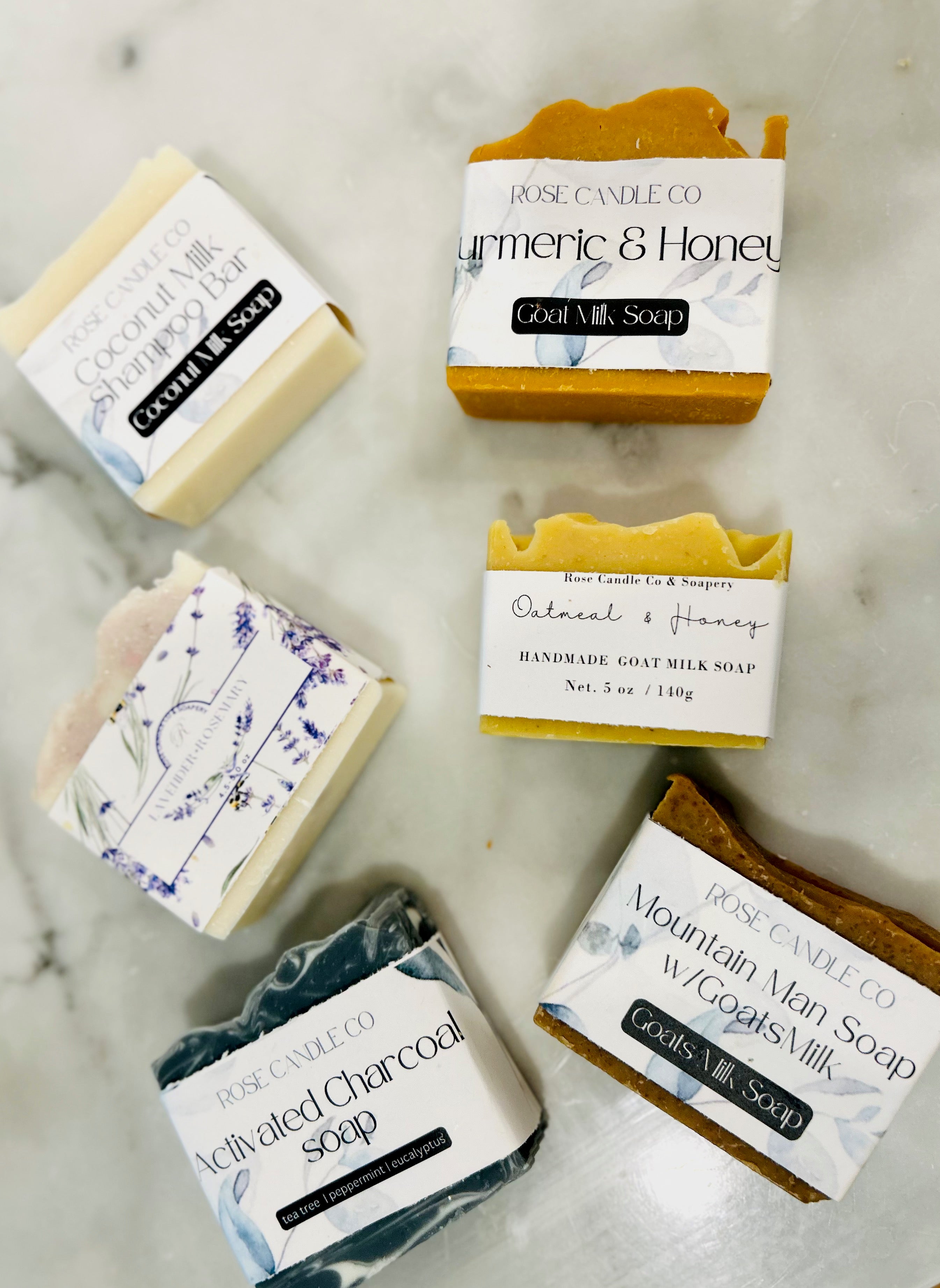 6 bars of various handmade soap on a marble countertop