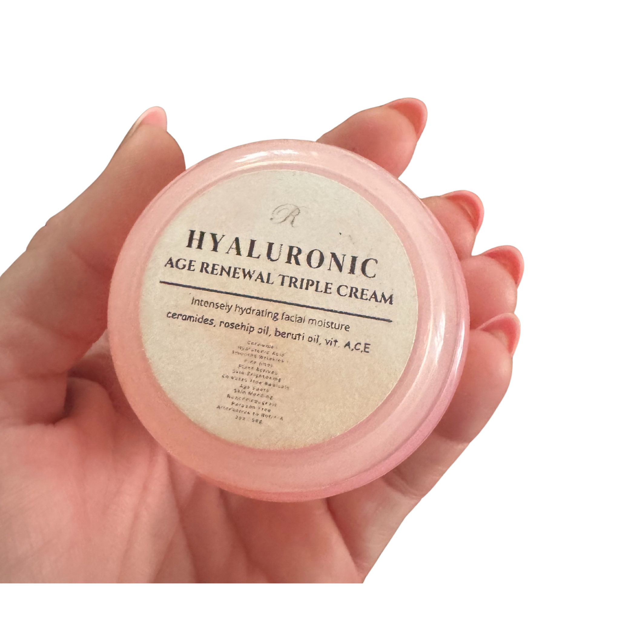Hand holding a pink container of Hyaluronic Age Renewal Triple Cream against a white background